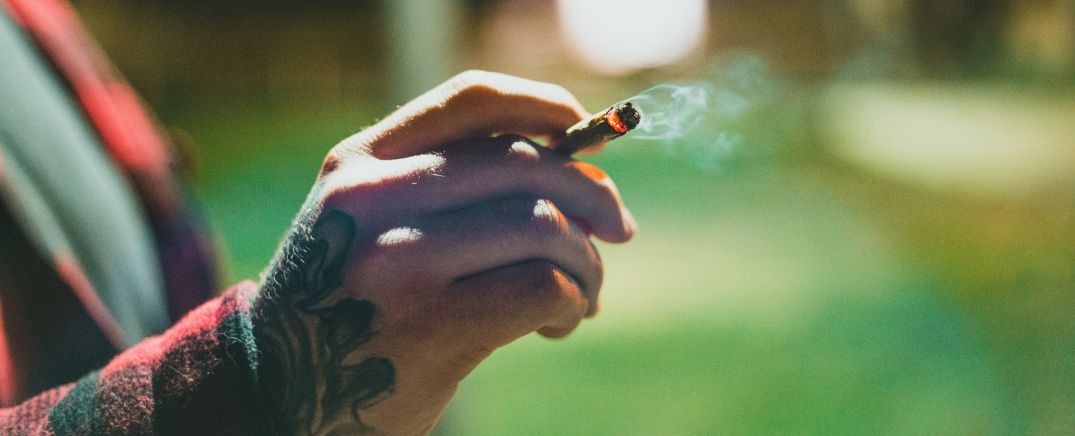 Adulto fumando cannabis, imagen relacionada con las señales de dependencia al cannabis en personas adultas.