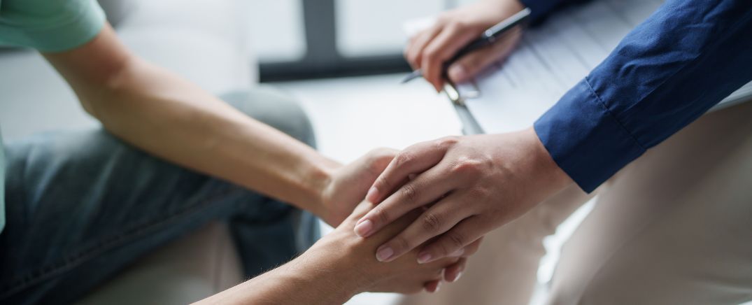 Profesional de la salud ofreciendo apoyo a una persona, imagen relacionada con el tratamiento y la recuperación de la dependencia al cannabis.